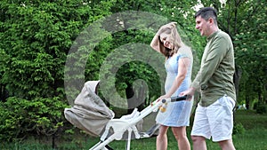 Amazed happy couple husband and wife wanders with buggy