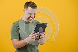 Amazed happy man using digital tablet looking shocked about social media news, astonished man shopper consumer surprised excited