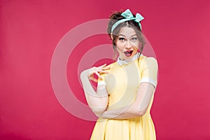 Amazed happy pinup girl in yellow dress