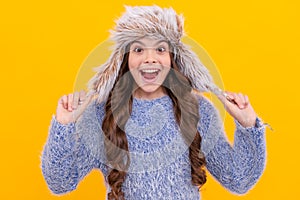 amazed kid with curly hair in earflap hat. female fashion model. teen girl in knitwear.