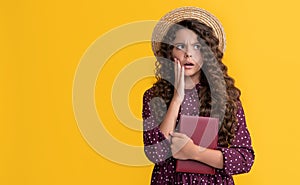 amazed kid with frizz hair hold book on yellow background