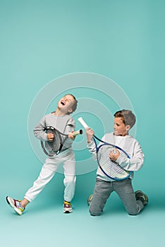 amazed kids holding tennis rackets while