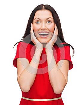 Amazed laughing young woman in red dress