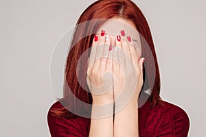 Amazed lovely woman covering face with hand