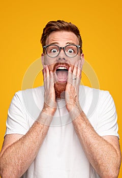 Amazed man in glasses looking at camera