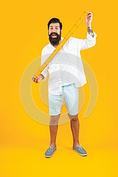 amazed man with measuring ruler in studio. man with measuring ruler on background.