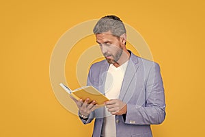 amazed man reader reading book in jacket. studio shot of man reader reading book. photo of man