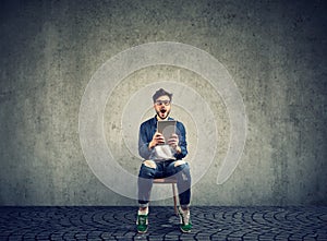 Amazed man with tablet on gray background