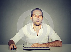 Amazed man using computer at desk