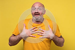 Amazed mature man holding hands in surprised gesture, keeping mouth wide open