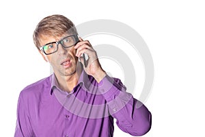 Amazed middle age man with glasses talking on the phone on white background