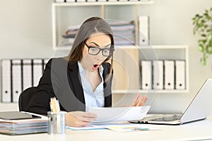 Amazed office worker reading sales report