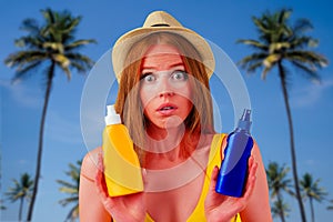 Amazed redhaired ginger woman holding two plastic bottle of suncream,facial expression i don`t know . copyspase studio
