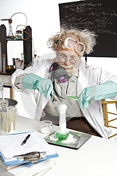 Amazed senior scientist with foaming beaker photo