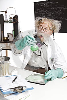 Amazed senior scientist with foaming beaker photo