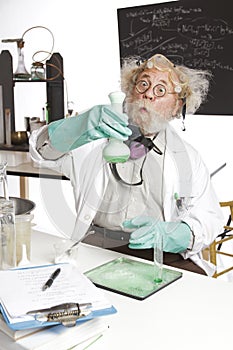 Amazed senior scientist with foaming beaker photo
