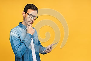 Amazed serious bearded man using digital tablet looking shocked about social media news, astonished man shopper consumer surprised