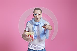 man using remote controller watching movie with big bucket of popcorns