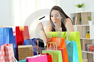 Amazed shopper looking at multiple purchases