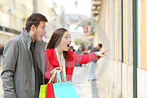 Amazed shoppers finding sales in a storefront