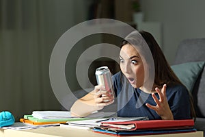 Amazed student looking at energy drink photo