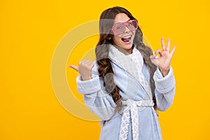 Amazed teen girl. Portrait of teenage girl in funny glasses and pajama or home bathrobe feeling fun. Kids pajama party