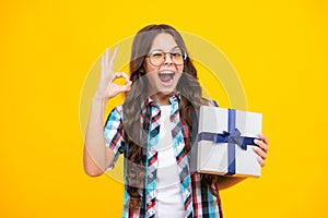 Amazed teen girl. Portrait of teenager child girl 12, 13, 14, years old holding Christmas gift box. Teen giving birthday