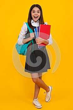 Amazed teen girl. School teenager child girl with school backpack hold book and copybook. Teenager student, isolated