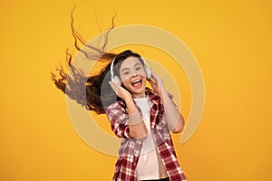 Amazed teenager. Child music concept. Teenager child girl dances in rhythm of melody, listens song in headphones. Child