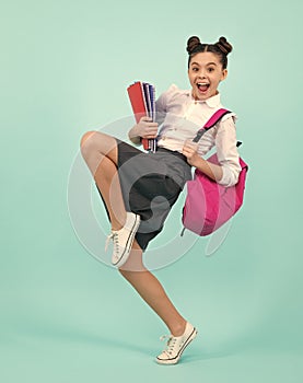 Amazed teenager. School teenage girl with book and copybook. Teenager schoolgirl student, isolated background. Learning