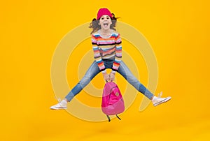 Amazed teenager. Winter school. Teenager school girl with backpack in autumn clothes on yellow isolated studio