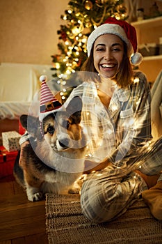 Amazed woman celebration Christmas holidays together with her pet Corgi dog