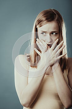Amazed woman covering her mouth with hands