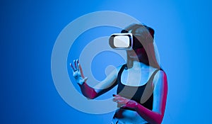 Amazed woman getting experience using glasses of virtual reality and exploring a virtual world. Girl spend shes time in