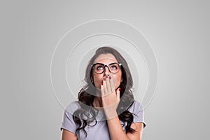 Amazed woman in glasses looking up