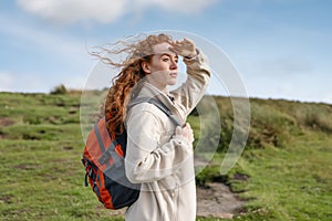 amazed Woman in jacket reaching the destination and taking selfie and shouting on the top of mountain at sunset. Travel Lifestyle