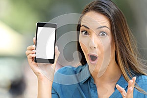 Amazed woman showing a blank smart phone screen