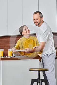 amazed woman smiling near husband serving