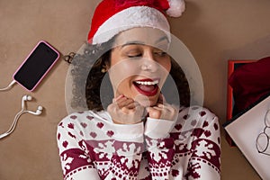 Amazed woman wearing christmas hat and seasonal sweater looking