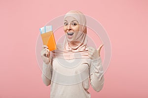 Amazed young arabian muslim woman in hijab light clothes posing isolated on pink background. People religious Islam