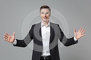 Amazed young business man in classic suit shirt isolated on grey background. Achievement career wealth business concept