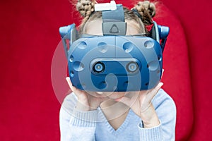 Amazed young girl experiencing virtual reality with a VR headset on the head.