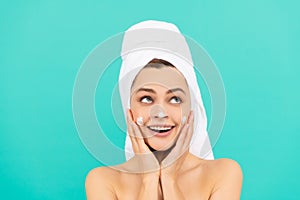 amazed young lady applying face cream on blue background