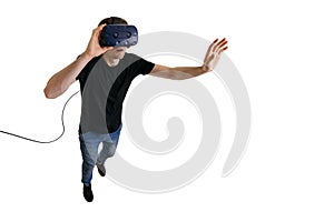 Amazed young man in 3d glasses experiencing virtual reality while flying in zero gravity on white background