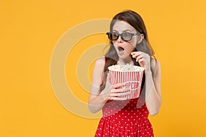 Amazed young woman girl in red summer dress, 3d glasses isolated on yellow background studio. People lifestyle concept