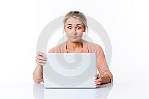 Amazed young woman sitting at clean desk staring at computer