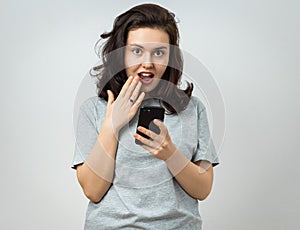 Amazed young woman with smartphone