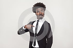 Amazement aloof afro man looking at camera. Studio shot, gray ba photo