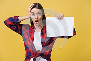 Amazement or surprised female with blank white panel, isolated on yellow background.