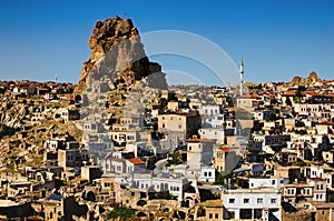 Amazing aerial landscape view of ancient Ortahisar cave city. Blue sky background. Popular travel destination in Turkey